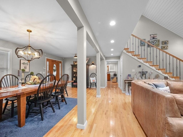 dining room featuring a chandelier, lofted ceiling, and light hardwood / wood-style flooring