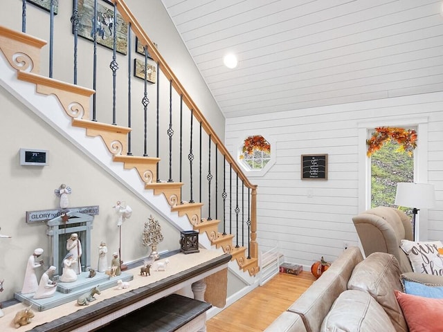 staircase featuring vaulted ceiling and hardwood / wood-style flooring