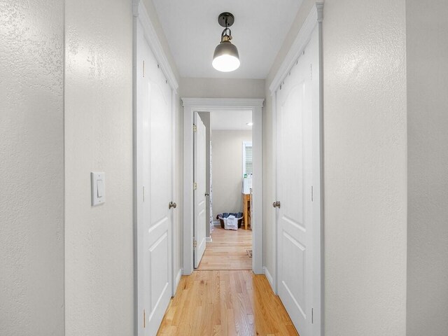 corridor with light hardwood / wood-style floors