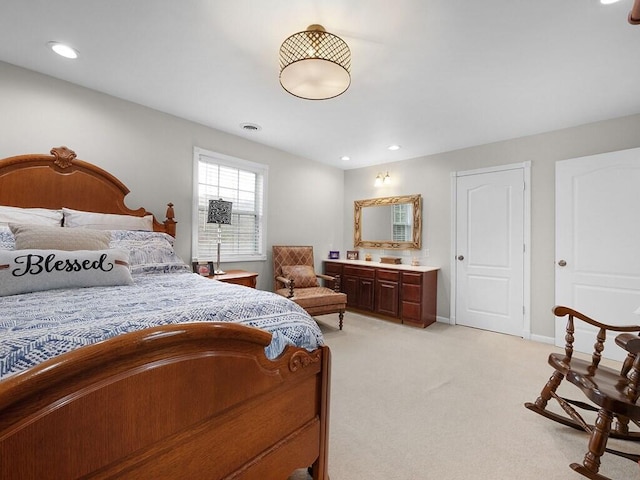 bedroom with connected bathroom and light colored carpet