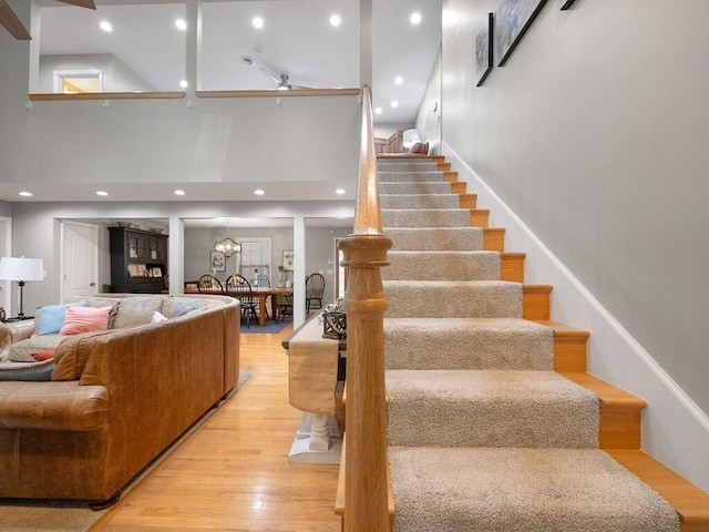 staircase with hardwood / wood-style floors and a high ceiling