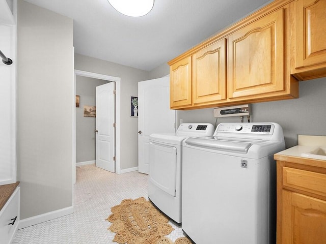 washroom featuring cabinets, light tile patterned floors, and washing machine and clothes dryer