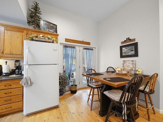 kitchen with a kitchen breakfast bar, light hardwood / wood-style flooring, and white refrigerator