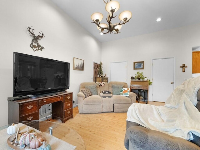 living room featuring an inviting chandelier, high vaulted ceiling, and light wood-type flooring