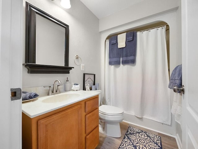 full bathroom featuring vanity, wood-type flooring, shower / tub combo, and toilet