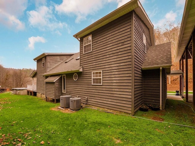 back of property with a lawn and central air condition unit