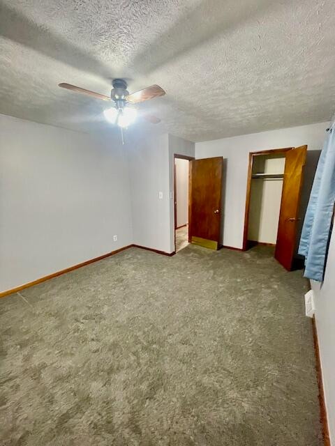 unfurnished bedroom featuring two closets, ceiling fan, carpet, and a textured ceiling