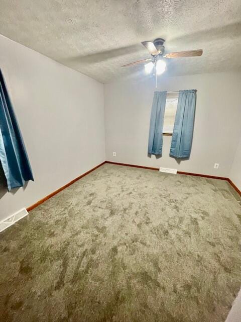 carpeted spare room featuring a textured ceiling and ceiling fan