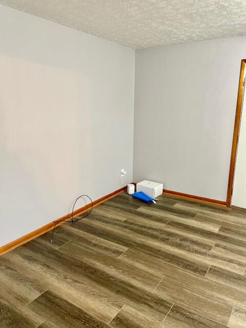 unfurnished room featuring a textured ceiling and hardwood / wood-style flooring