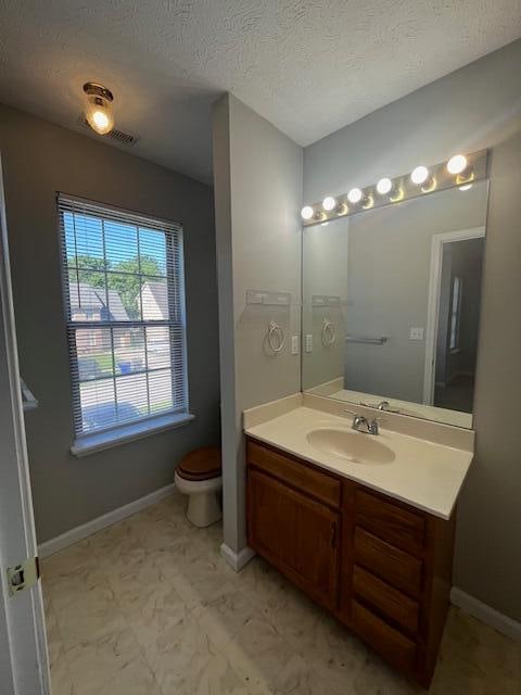 bathroom with vanity, a textured ceiling, and toilet