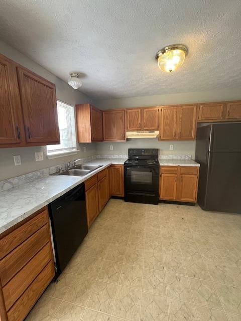 kitchen with black appliances, sink, and a textured ceiling