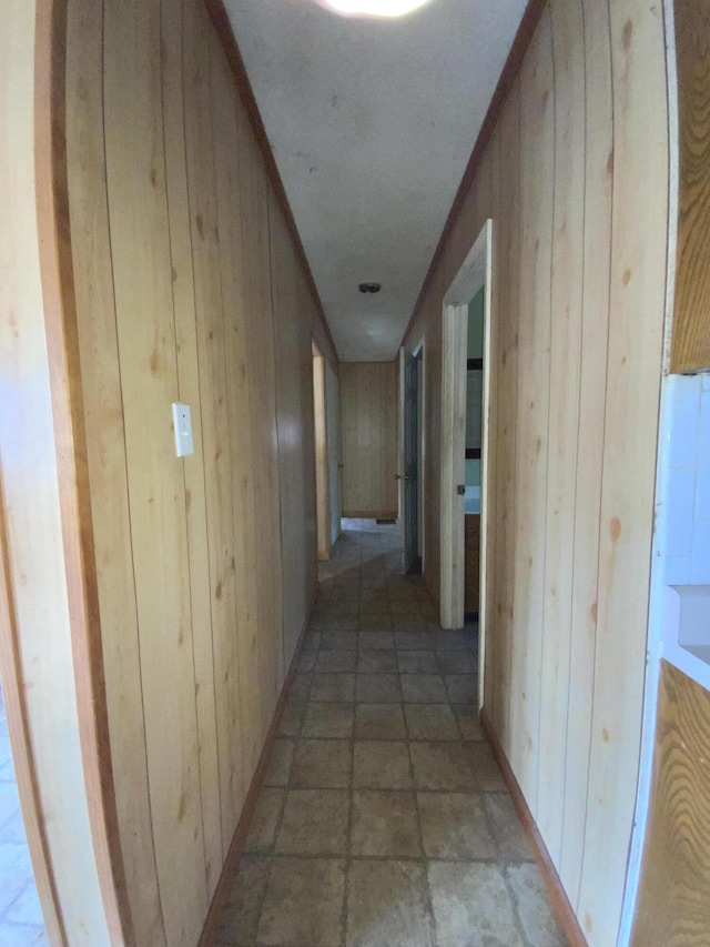 hallway featuring wooden walls