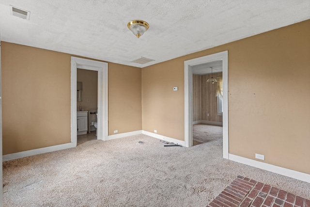 unfurnished room featuring carpet flooring and a textured ceiling