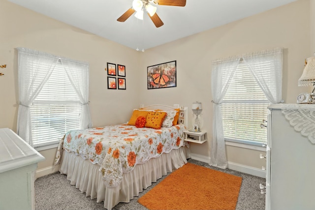 carpeted bedroom with ceiling fan and multiple windows