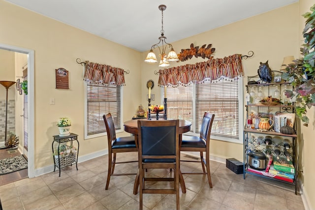 dining area with light tile patterned floors and a chandelier