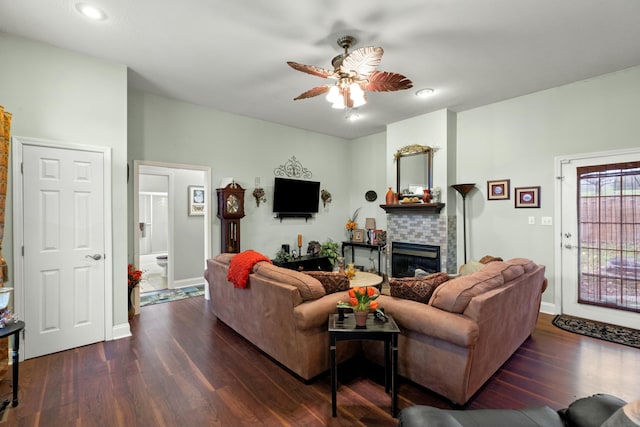 living room with a fireplace, ceiling fan, and dark hardwood / wood-style flooring