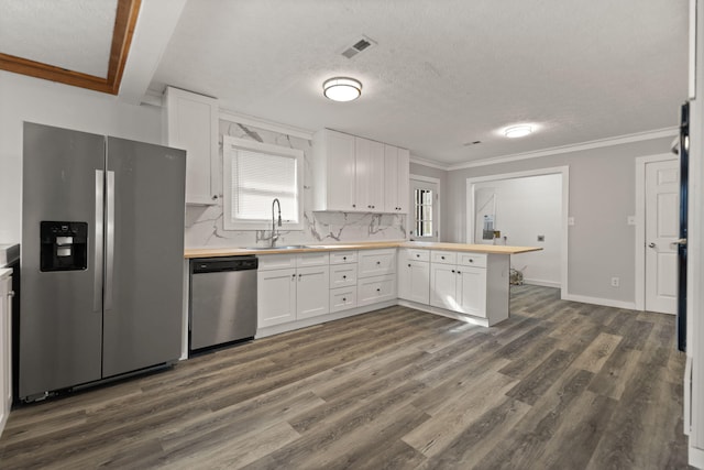 kitchen featuring appliances with stainless steel finishes, dark hardwood / wood-style flooring, tasteful backsplash, sink, and white cabinetry