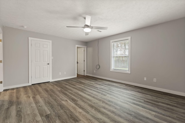 unfurnished bedroom featuring a textured ceiling, ceiling fan, and dark wood-type flooring