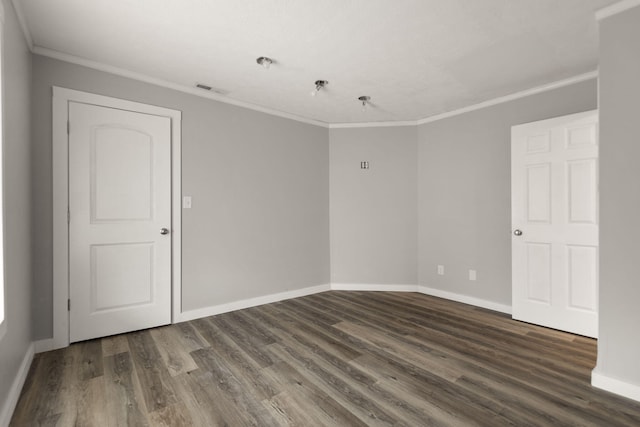 spare room featuring dark hardwood / wood-style flooring and ornamental molding