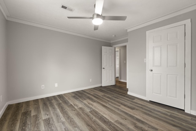 unfurnished bedroom featuring dark hardwood / wood-style flooring, ceiling fan, and crown molding