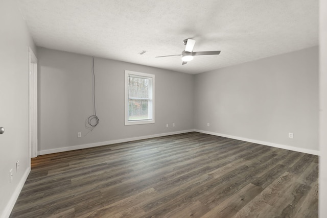 empty room featuring a textured ceiling, dark hardwood / wood-style floors, and ceiling fan