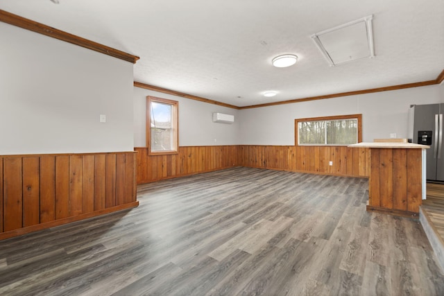 unfurnished living room with plenty of natural light, dark hardwood / wood-style floors, and crown molding