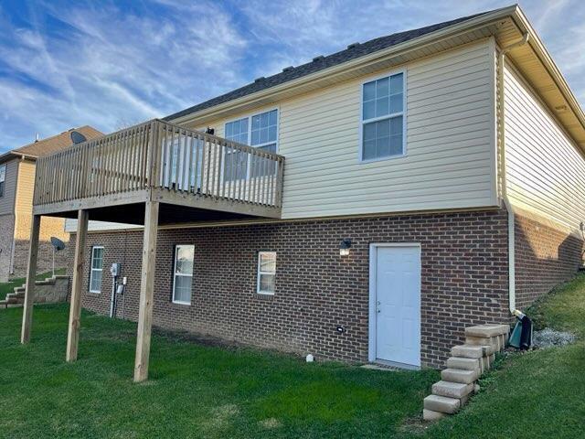 rear view of house with a lawn and a deck