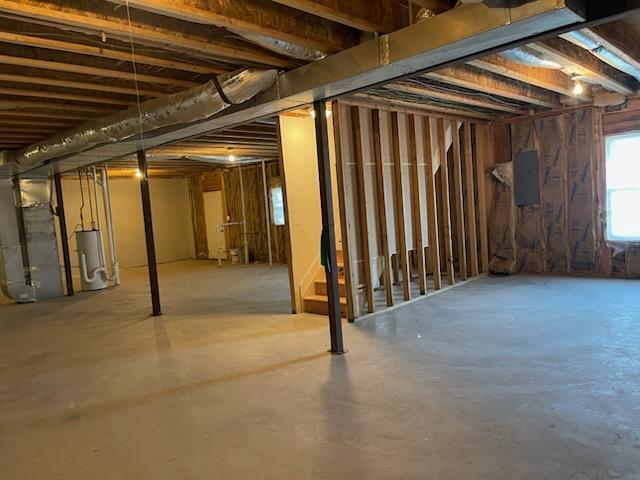 basement with electric panel and electric water heater