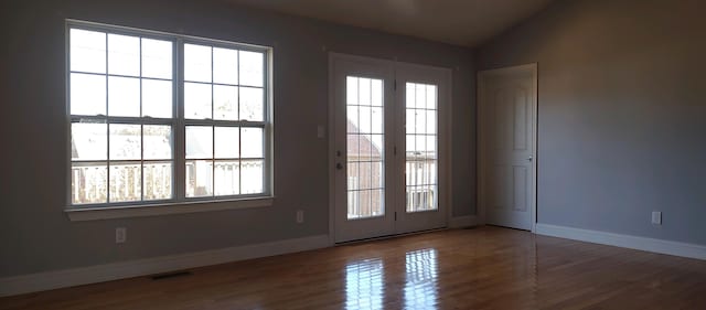 doorway to outside with wood-type flooring and vaulted ceiling