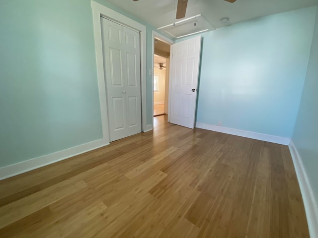 unfurnished bedroom featuring ceiling fan, wood-type flooring, and a closet