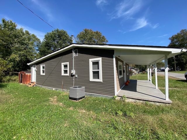 rear view of house with a lawn and central AC unit