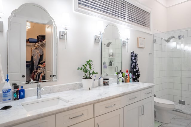 bathroom with marble finish floor, a sink, a stall shower, and double vanity