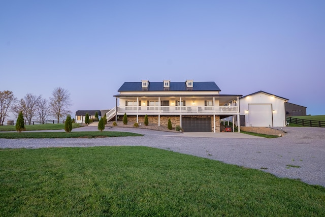 view of front of property featuring fence, driveway, a garage, a yard, and roof mounted solar panels