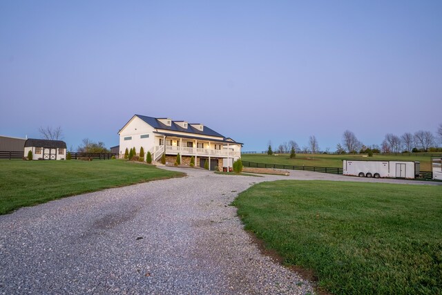 view of front of home featuring a yard, solar panels, and covered porch