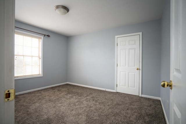 empty room featuring dark carpet