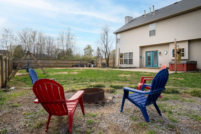 view of yard featuring a hot tub, an outdoor fire pit, and a patio area