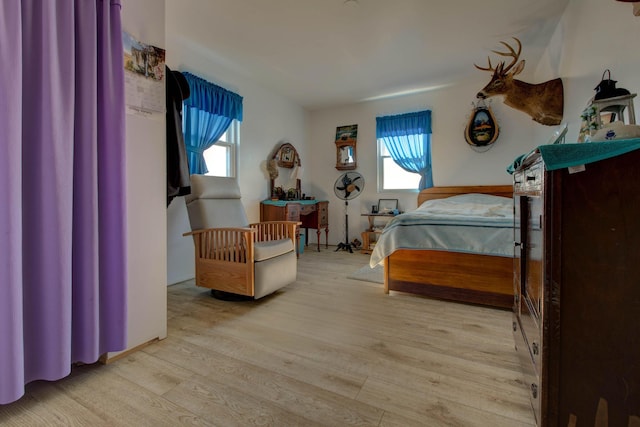 bedroom with multiple windows and light hardwood / wood-style floors