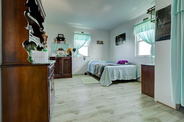 bedroom with light hardwood / wood-style floors and multiple windows