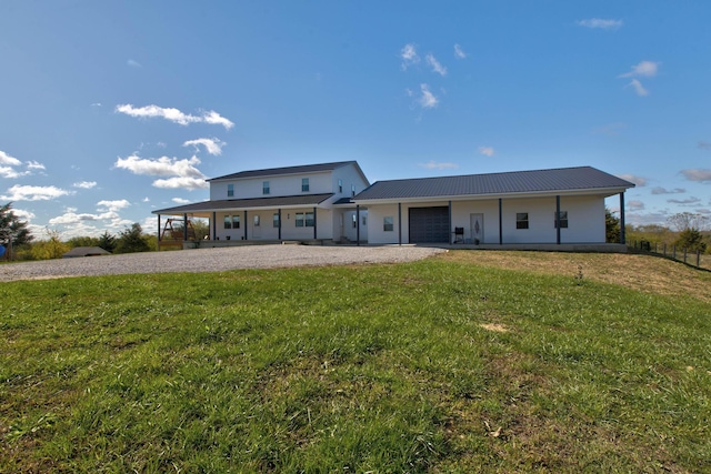 rear view of property featuring a garage and a yard