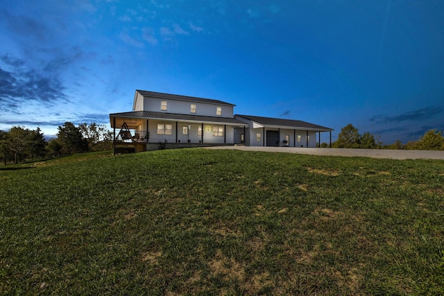 back house at dusk featuring a yard, a porch, and a carport