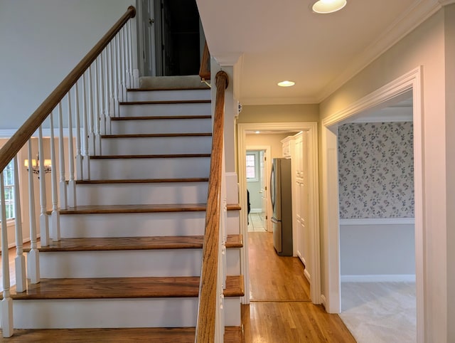 staircase featuring hardwood / wood-style flooring and crown molding