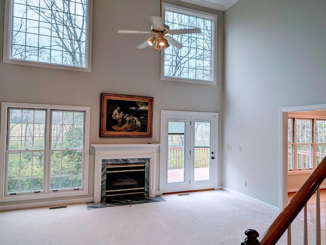 unfurnished living room featuring plenty of natural light and a high ceiling