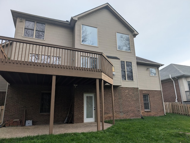 back of property with a wooden deck, a yard, and a patio