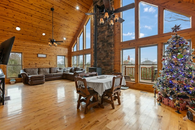 dining room featuring light hardwood / wood-style flooring, high vaulted ceiling, and a healthy amount of sunlight