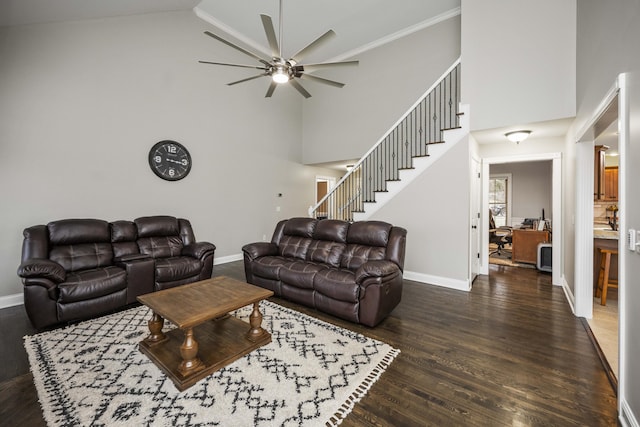 living room with ceiling fan, dark hardwood / wood-style flooring, and a high ceiling