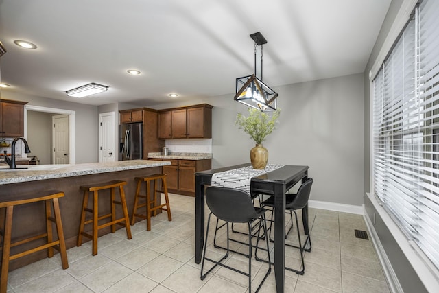 tiled dining room with a healthy amount of sunlight and sink