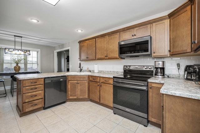 kitchen featuring pendant lighting, sink, backsplash, stainless steel appliances, and kitchen peninsula