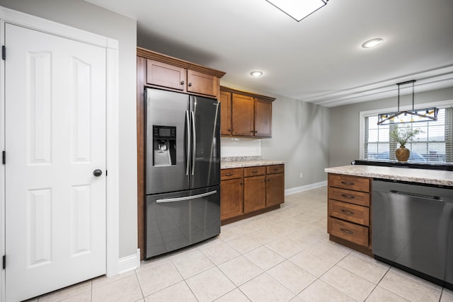 kitchen with appliances with stainless steel finishes, backsplash, hanging light fixtures, light tile patterned floors, and light stone countertops