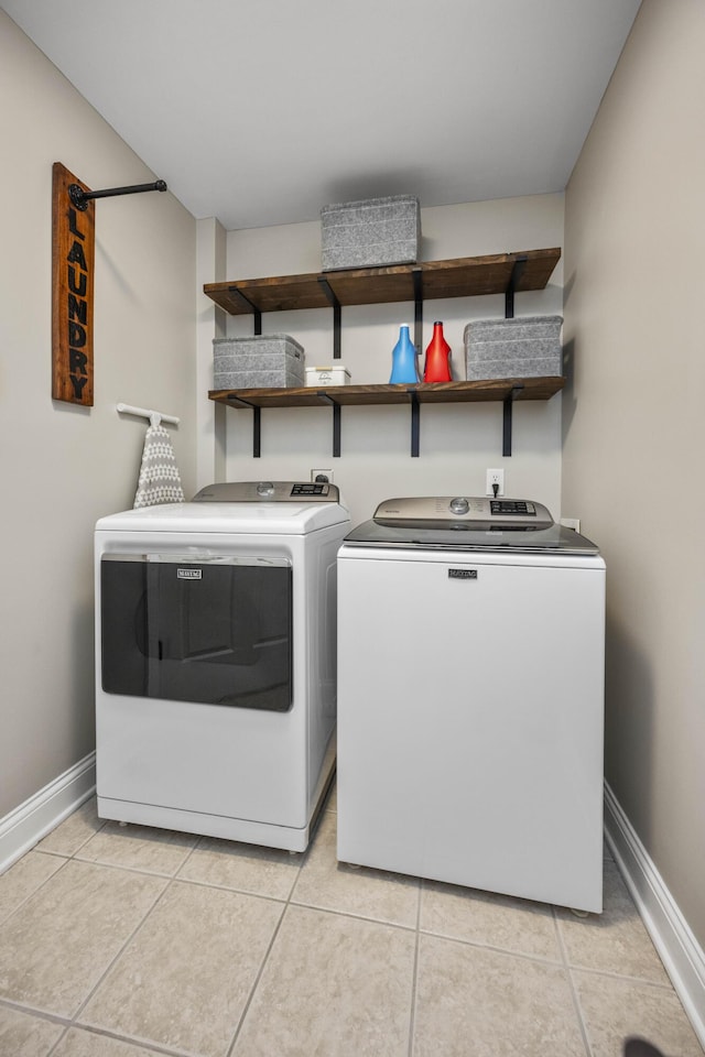 laundry area featuring separate washer and dryer and light tile patterned floors