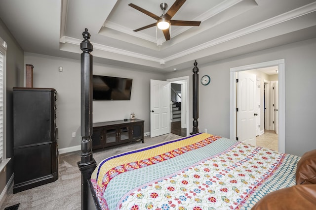 carpeted bedroom featuring ceiling fan, ornamental molding, and a tray ceiling